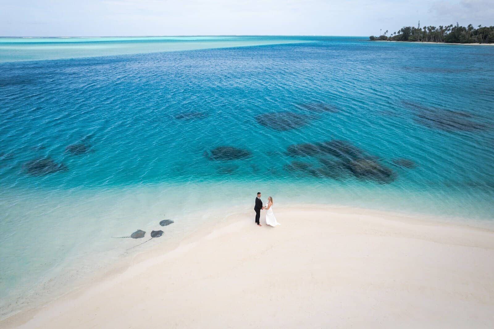 Aerial view of a wedding couple and stingrays in the Bora Bora lagoon