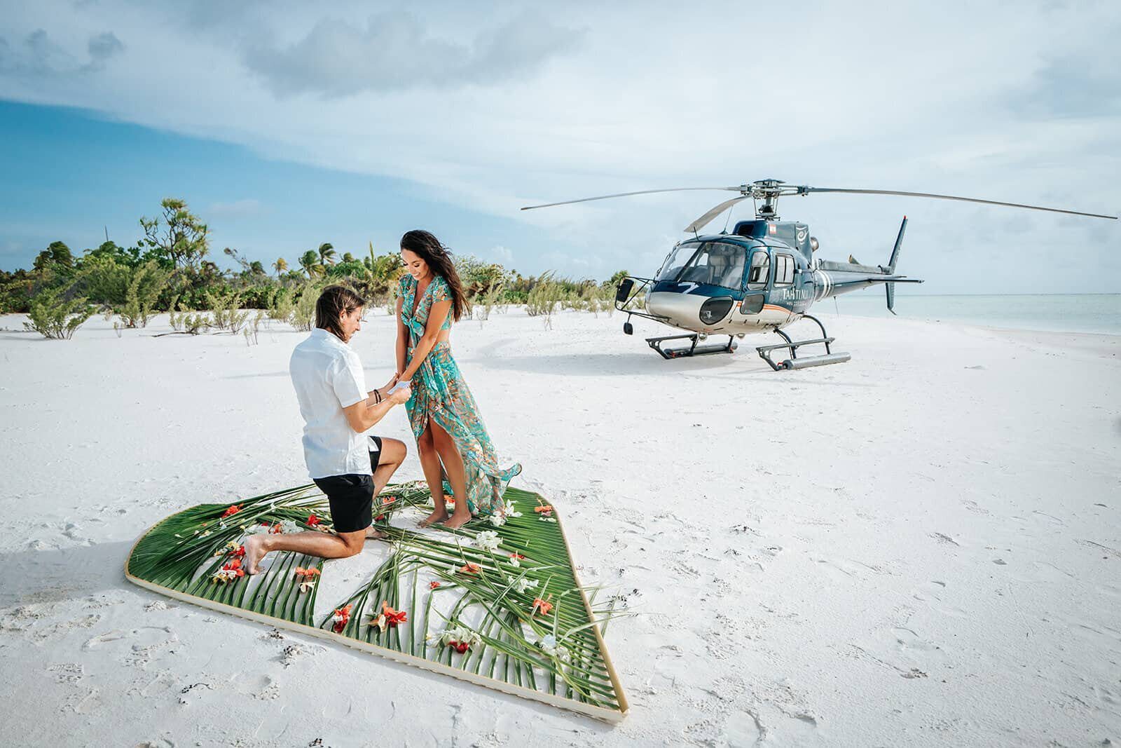 Surprise proposal beside a helicopter on a private motu in Bora Bora