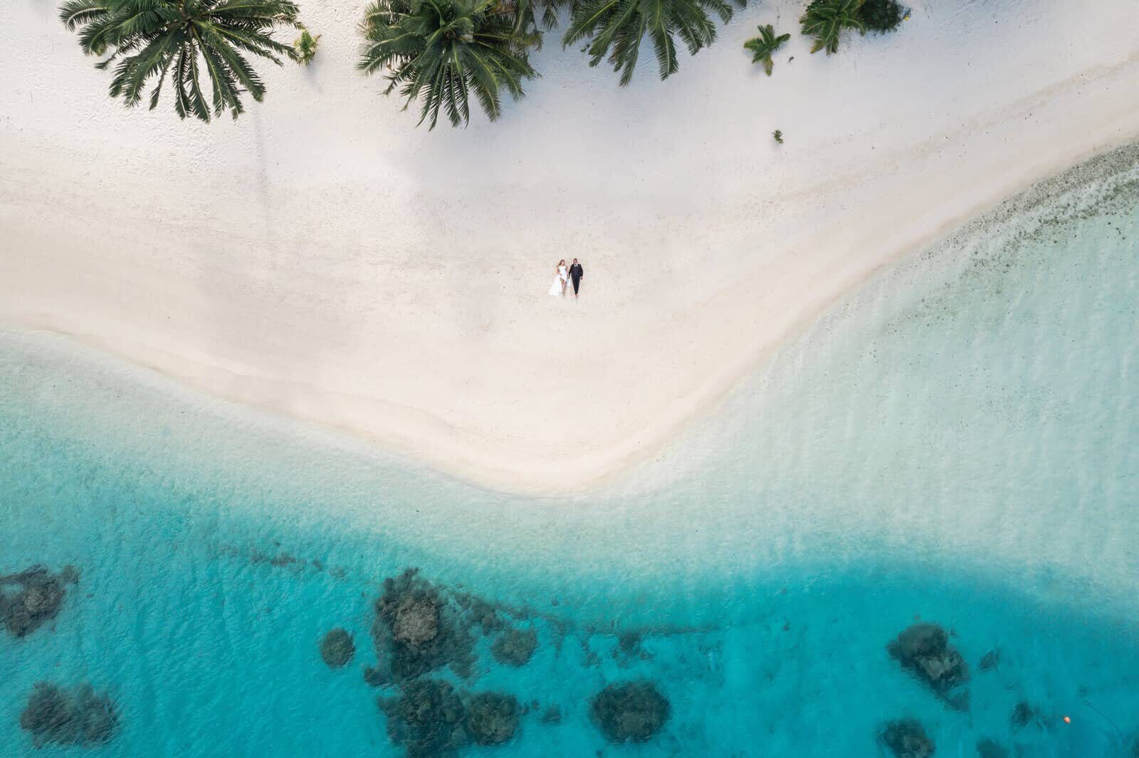 Wedding couple on a Bora Bora beach beside the lagoon