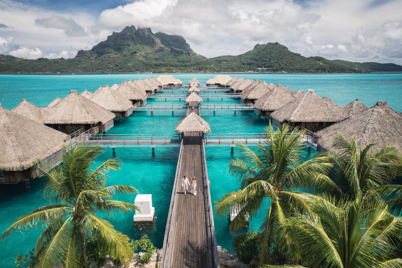 Wedding couple on a walkway among the overwater villas at The St. Regis Bora Bora